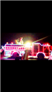 Fire Engine Lined with Christmas Lights Driving in a Parade