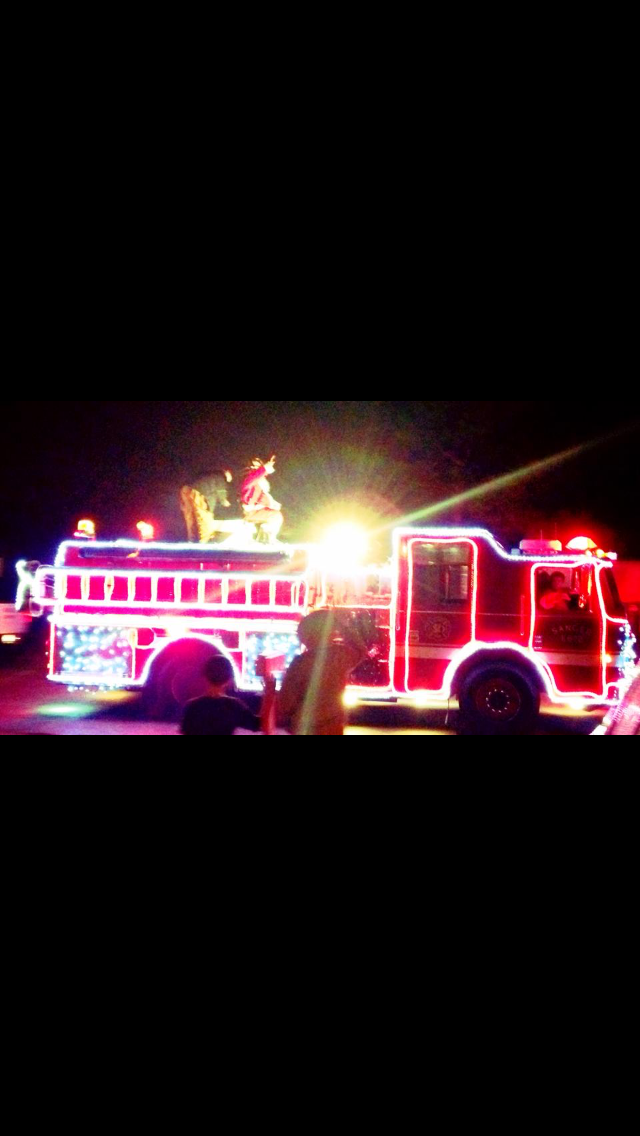 Fire Engine Lined with Christmas Lights Driving in a Parade