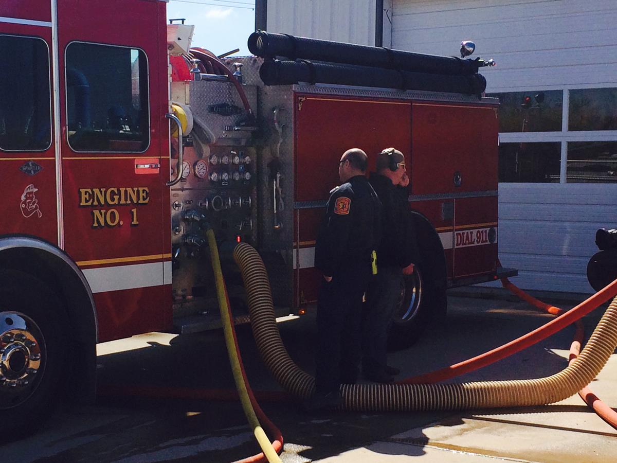Two Officers Performing Maintenance on a Fire Engine 4