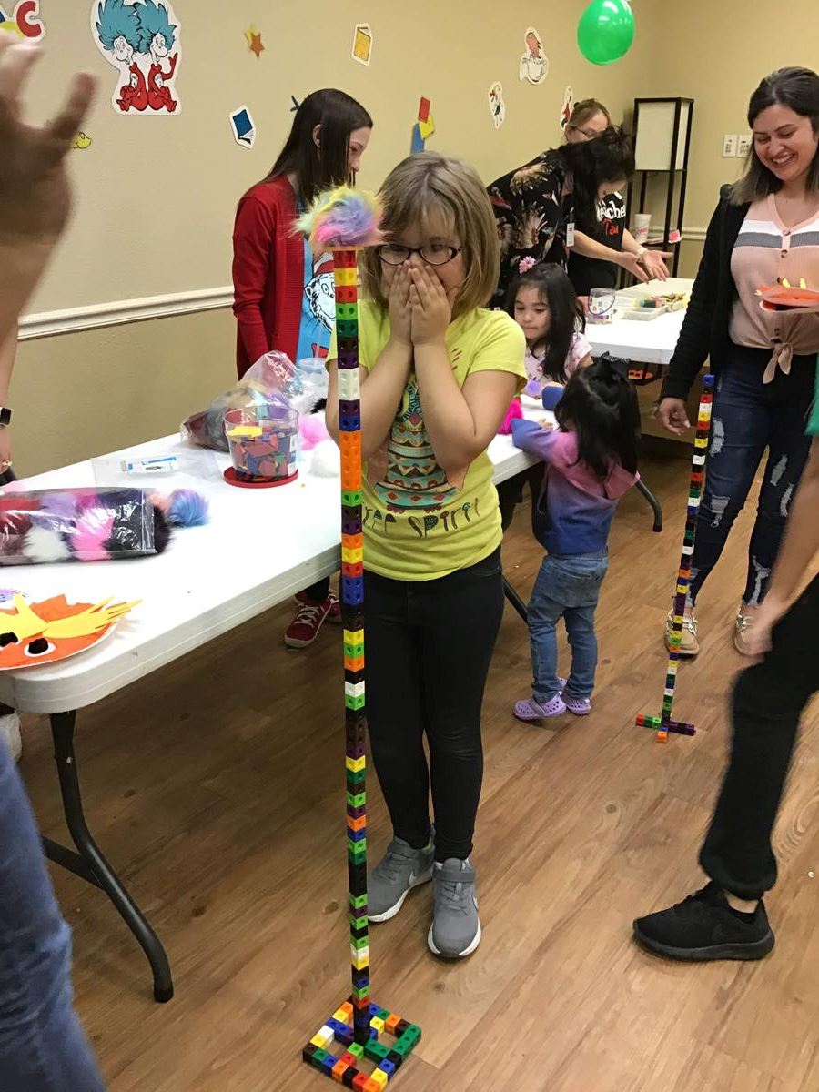Kids Building a Tall Tower out of Plastic Blocks